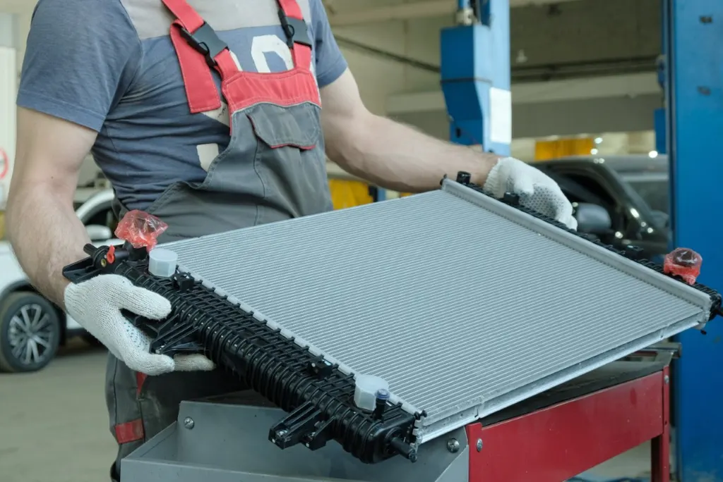 Technician holding a replacement radiator in the shop